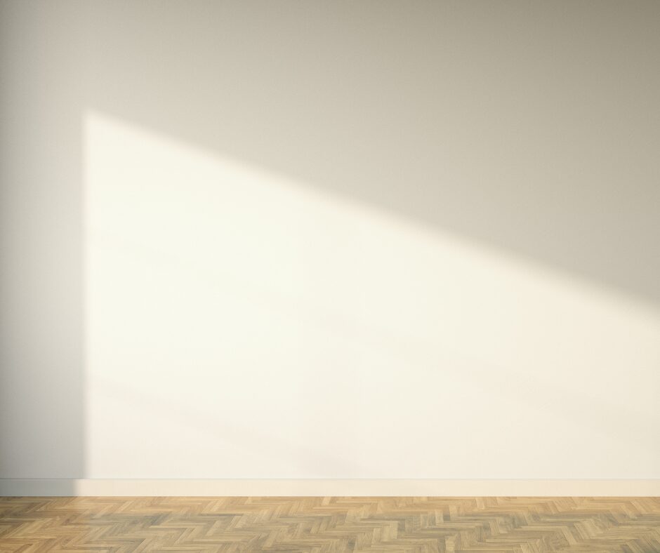 Na zdjęciu widać jasną ścianę, cień oraz fragment podłogi