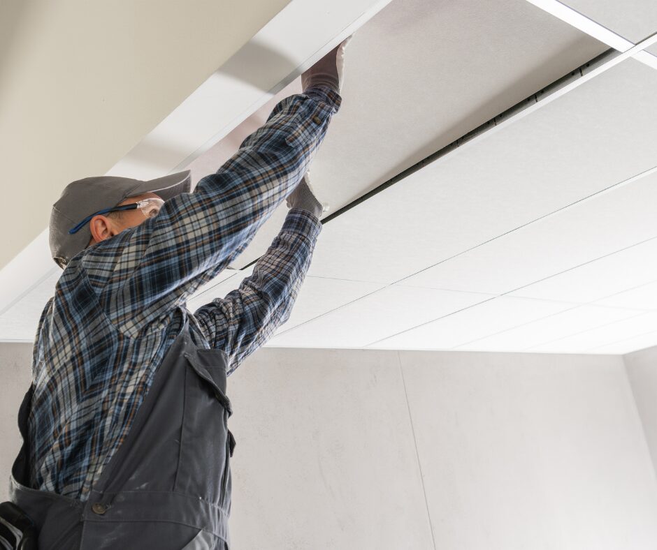 Pracownik budowy montuje sufit podwieszany