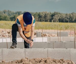 Pracownik budowy pracuje przy fundamentach budynku
