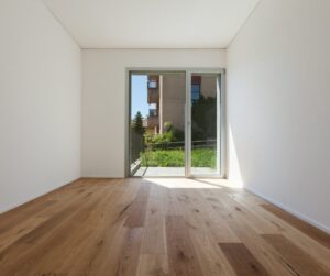 Panele imitujące drewno. Na drugim planie otwarty balkon domu. 